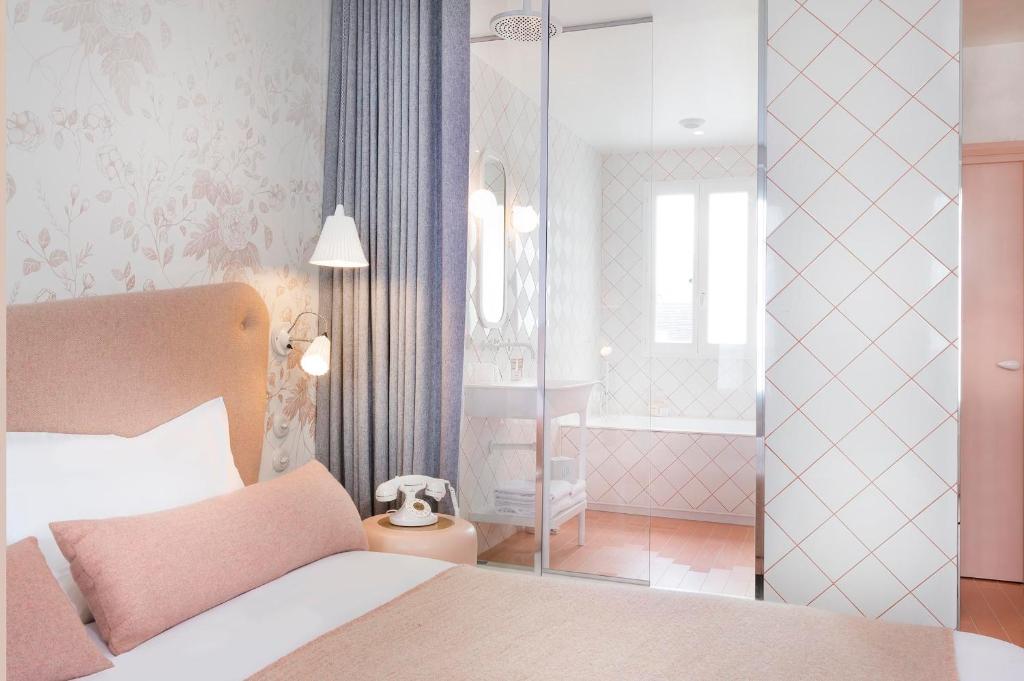 a bedroom with a large bed and a bathroom at Hotel le Lapin Blanc in Paris