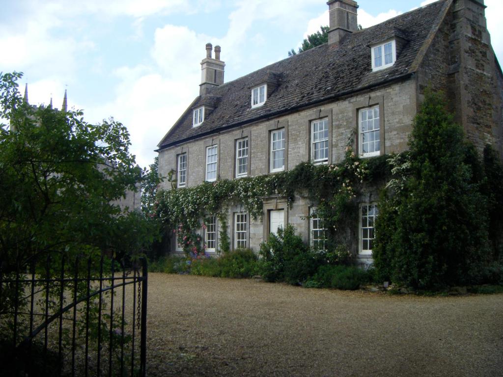 an old stone house with ivy on it at Teigh Old Rectory in Oakham