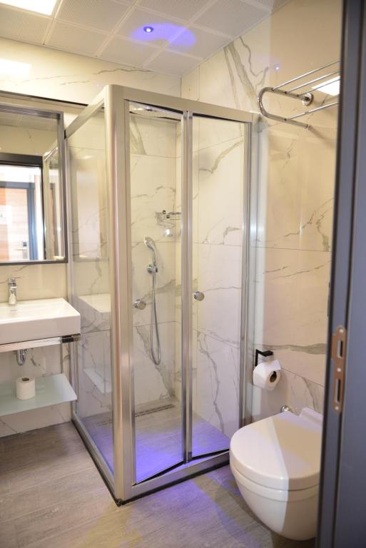 a bathroom with a shower and a toilet and a sink at Oasis Hotel in Marmaris