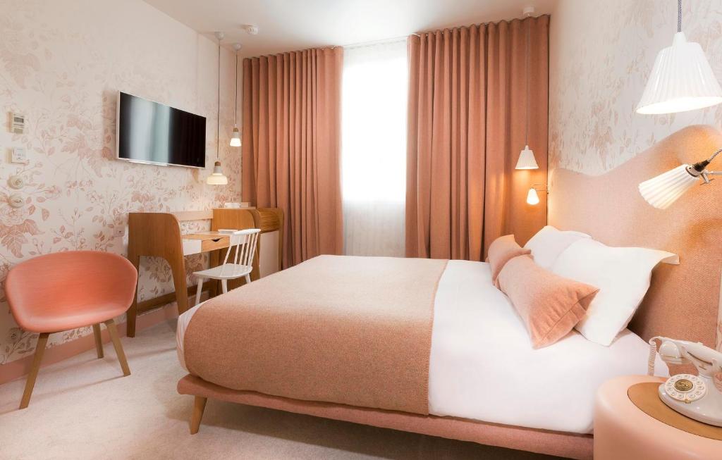 a hotel room with a large bed and a table at Hotel le Lapin Blanc in Paris