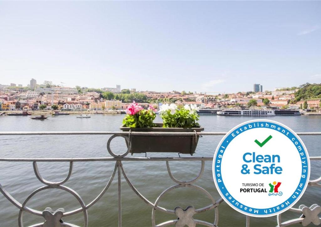 a sign that says clean and safe with flowers on a balcony at Porto Premium River View II in Porto