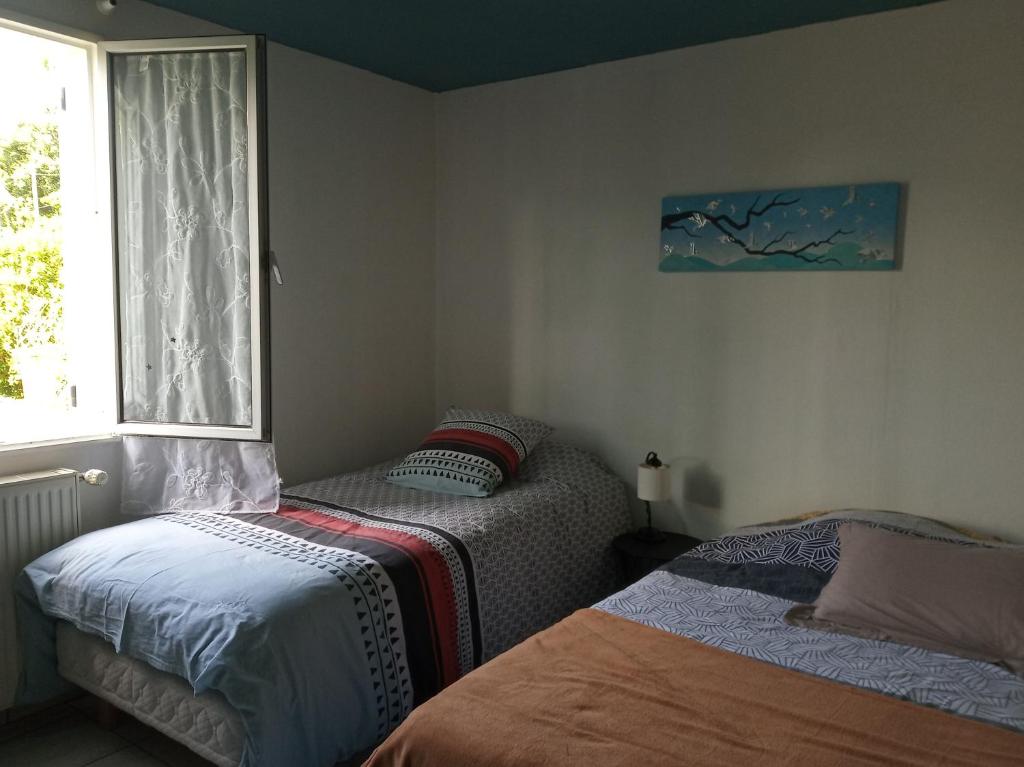 1 dormitorio con 2 camas y ventana en Figalrance Studio, en Plouër-sur-Rance