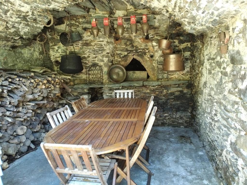 una mesa de madera y sillas en una habitación con horno en Gîte en Cévennes, en Sumène