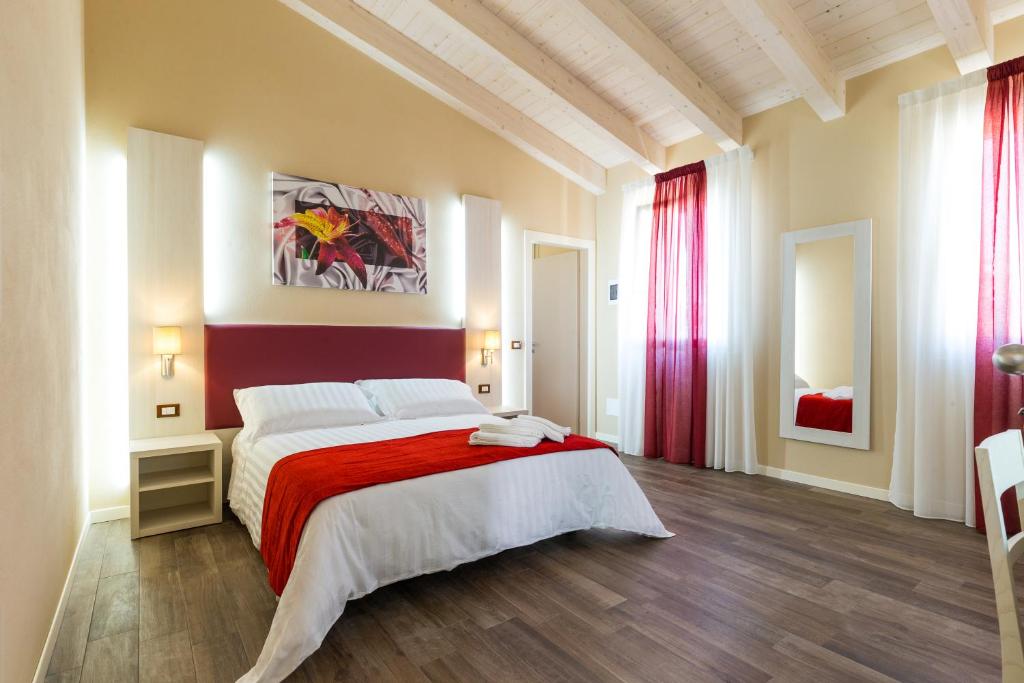 una camera da letto con un grande letto con una coperta rossa di Venice Airport Villa Erica a Campalto