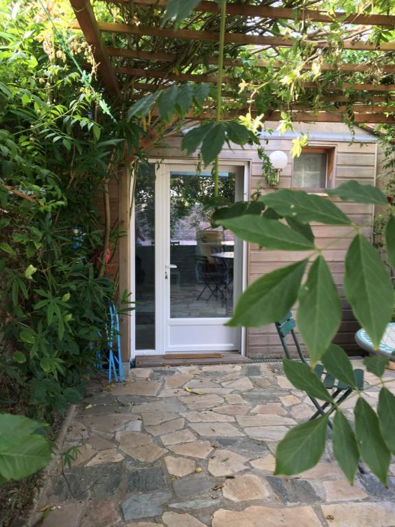 une porte d'entrée d'une maison avec une terrasse dans l'établissement Olive et Pomme, à Bretteville