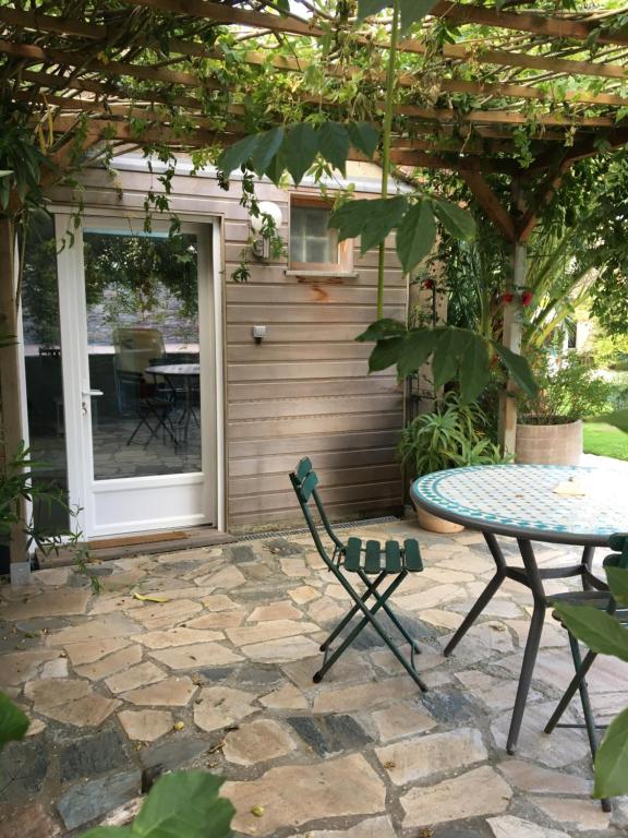 a patio with a table and a table and chairs at Olive et Pomme in Bretteville