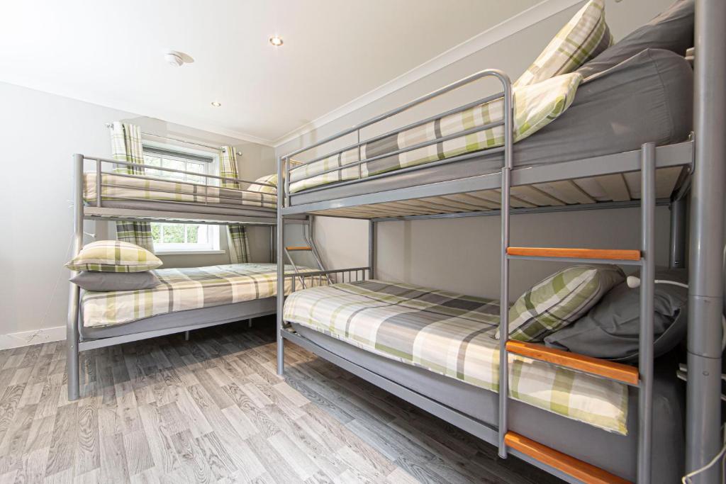 two bunk beds in a room with wooden floors at Ash Cottage in Merthyr Tydfil