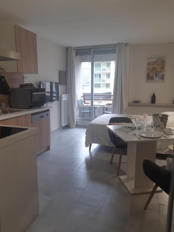 une cuisine et un salon avec une table et un lit dans l'établissement A la montagne à 2 App107, à Cauterets