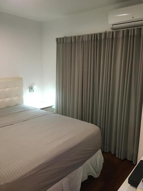 - une chambre avec un lit et une fenêtre avec des rideaux dans l'établissement Newciti Flat Itaim Bibi, à São Paulo