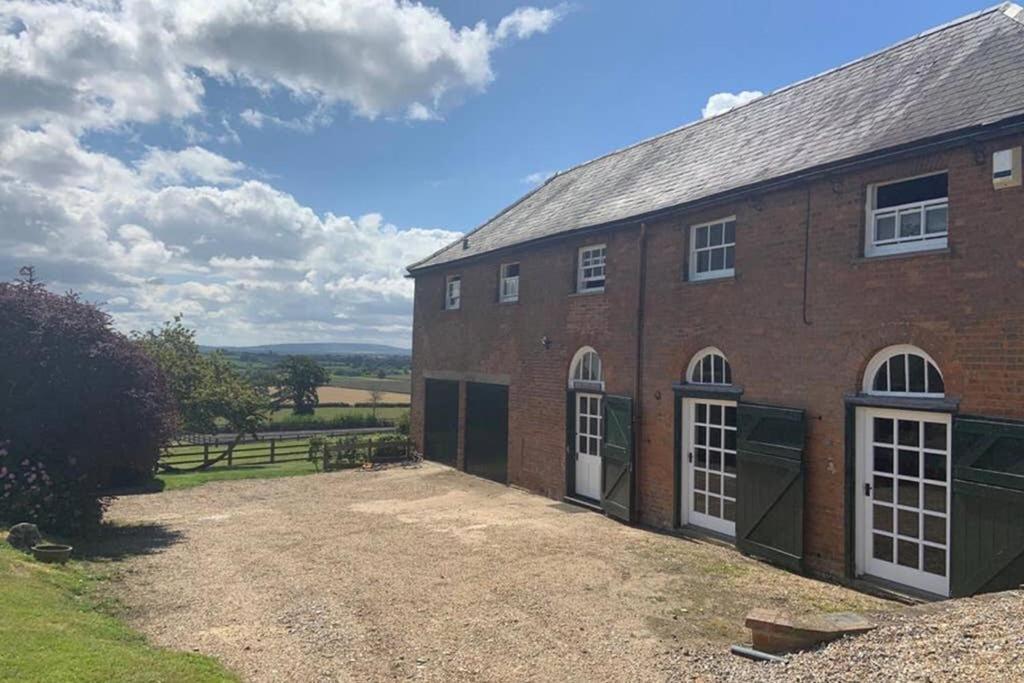 a large brick building with a large yard at Coach House in Weedon