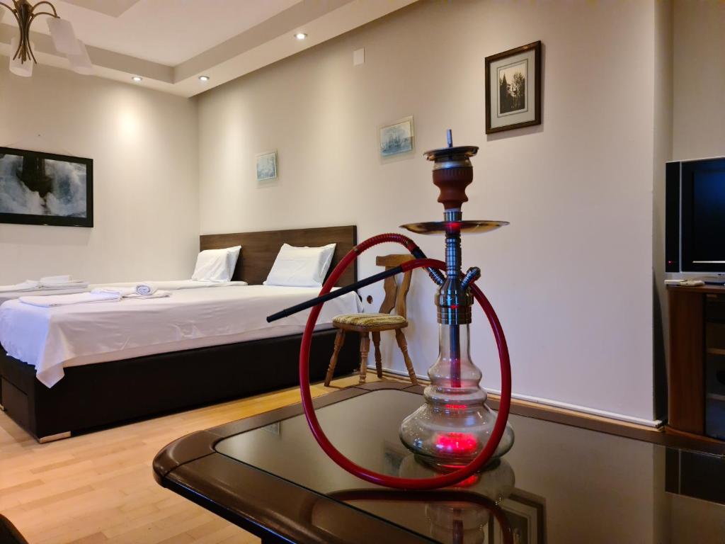 a room with a bed and a red hose on a table at City Center Apartments in Strumica