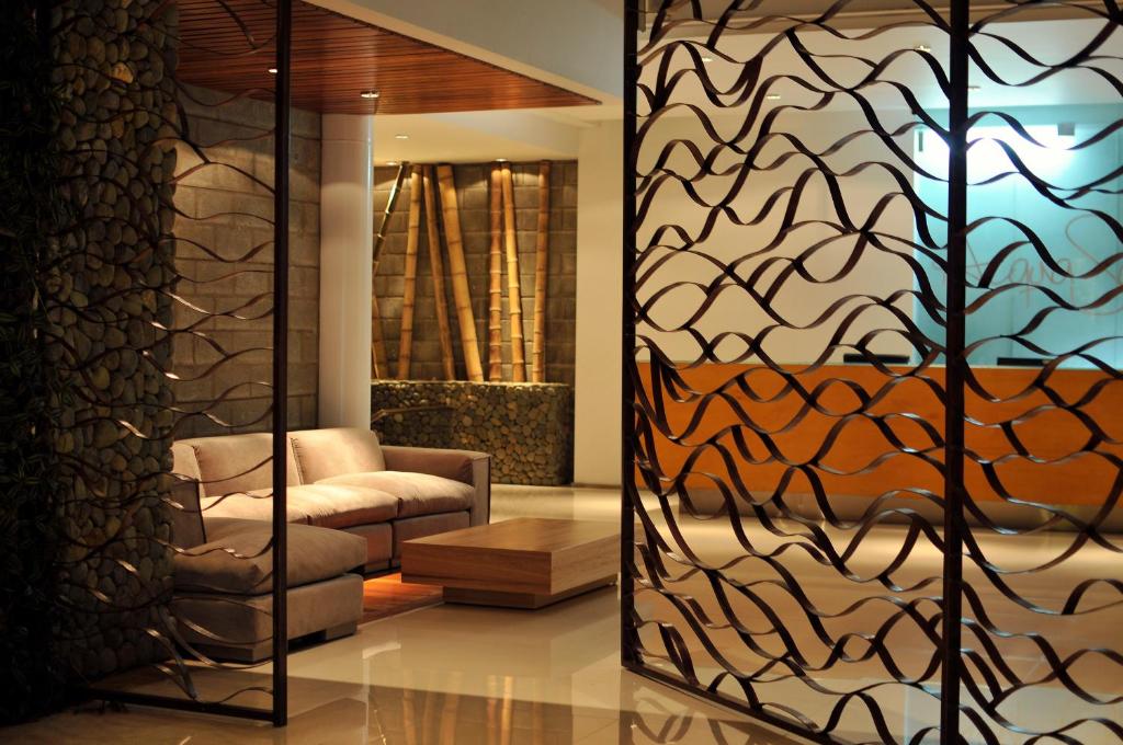 a living room with a chair and a glass door at AcquaSanta Lofts Hotel in Cali