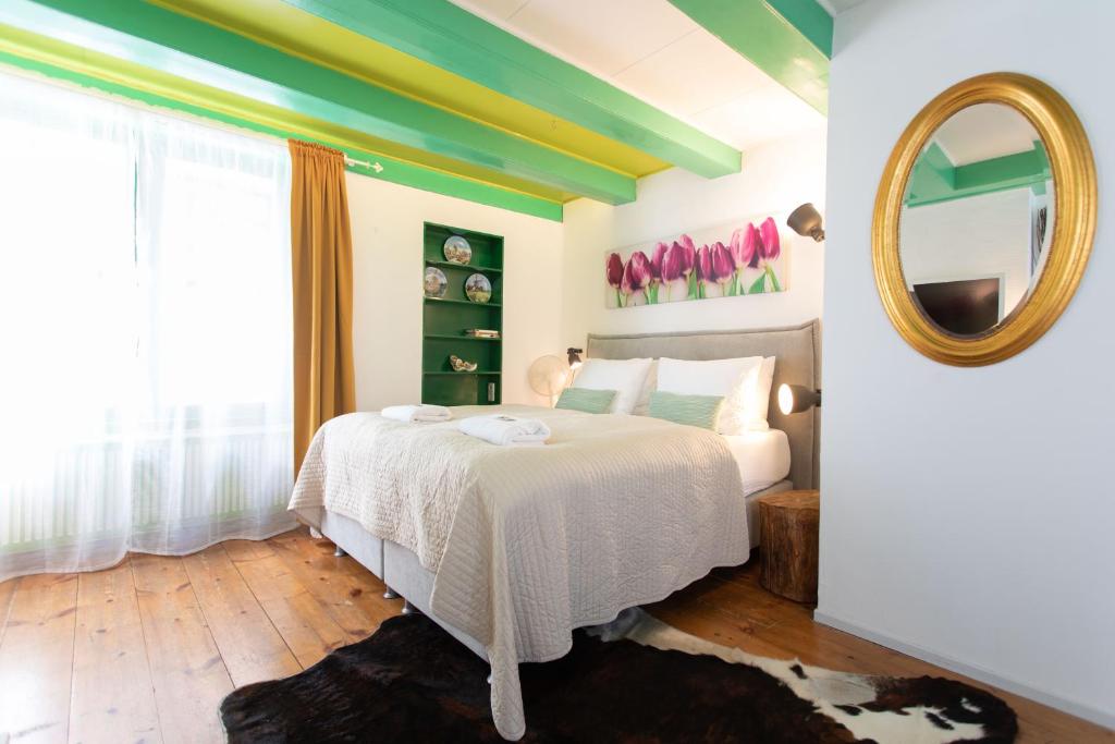 een slaapkamer met een bed en een spiegel bij Tulip of Amsterdam in Amsterdam