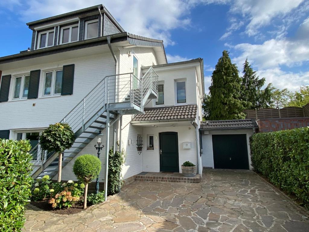 Una casa blanca con una escalera. en DG Wohnung mit separatem Eingang nahe Düsseldorf en Meerbusch