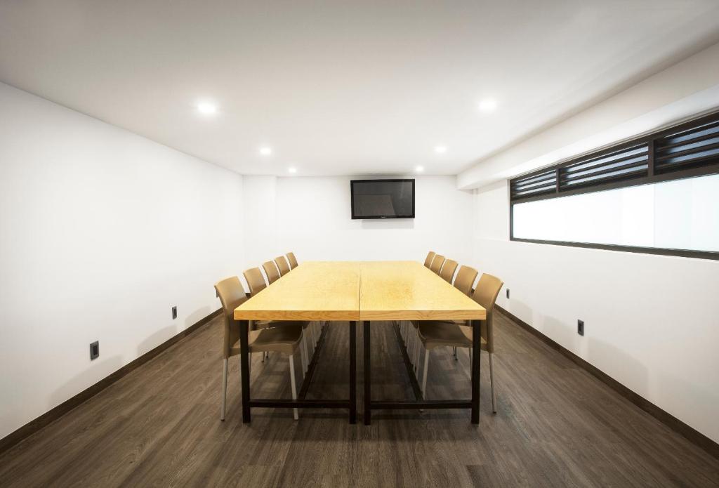 A simple enclosed meeting room centered on a long wooden conference table.