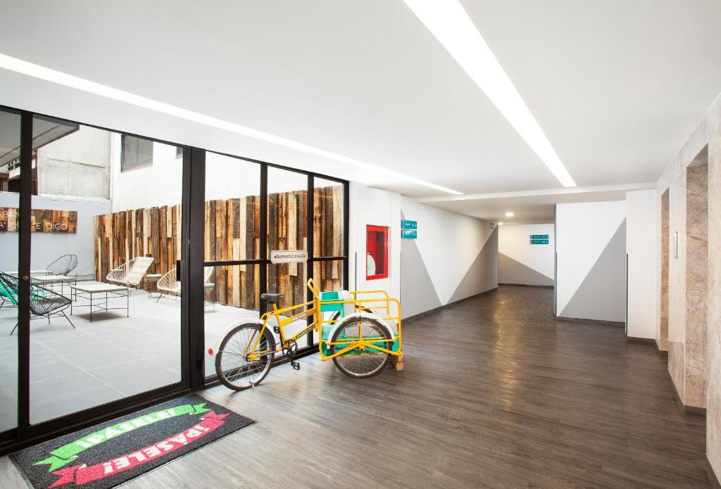 A bright hotel lobby corridor with loaner bicycles beside a glass-fronted patio.