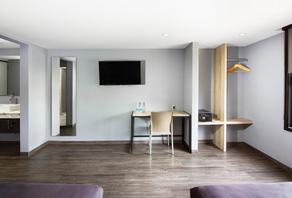 A compact in-room work area beneath a wall-mounted television.