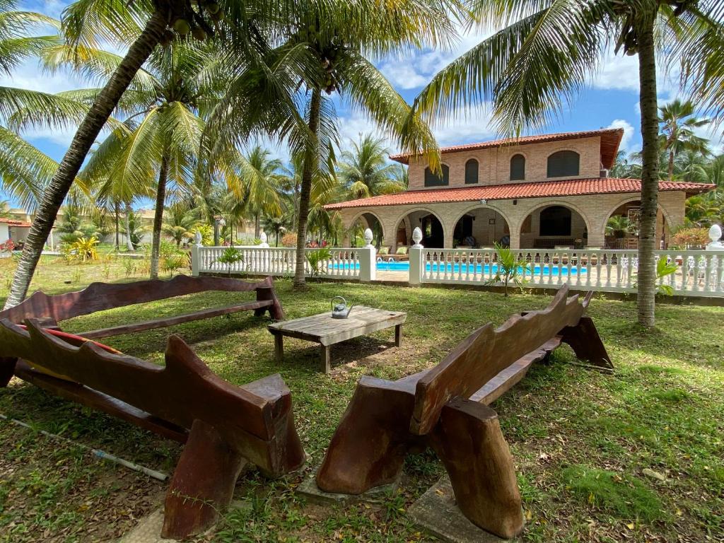聖米格爾－杜斯米拉格里斯的住宿－AQUALUNA POUSADA，一个带长椅的公园和一座棕榈树建筑