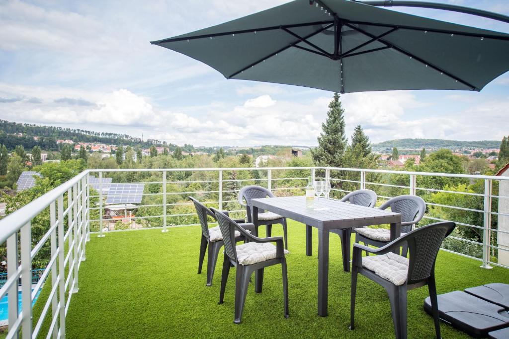 a table and chairs on a balcony with an umbrella at Weitblick-Ferienwohnung in Eisenach