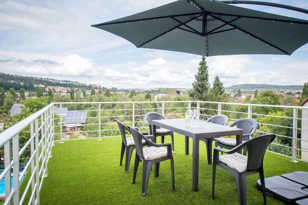 une table et des chaises sur un balcon avec un parasol dans l'établissement Weitblick-Ferienwohnung, à Eisenach