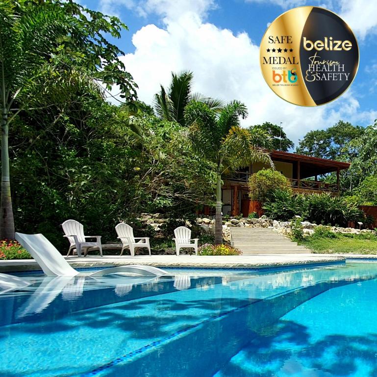 a swimming pool with two chairs and a beach ball at Vanilla Hills Lodge in San Ignacio