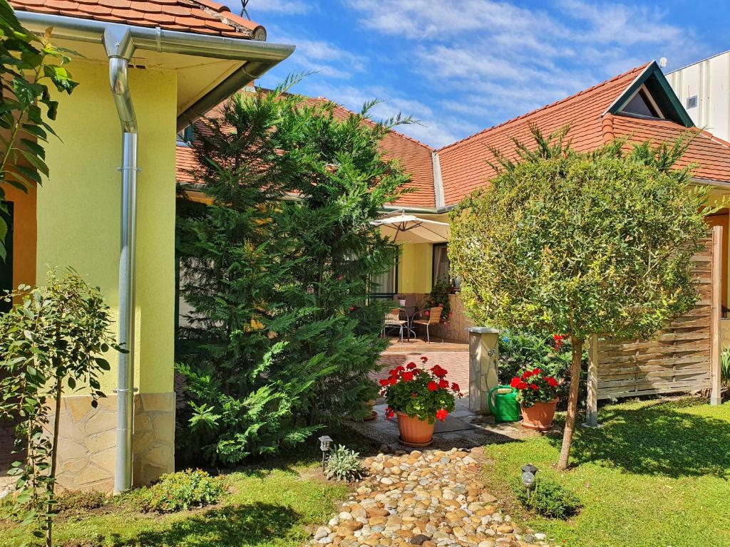 ein Haus mit einem Garten mit Blumen im Hof in der Unterkunft Gardenia Apartman in Esztergom