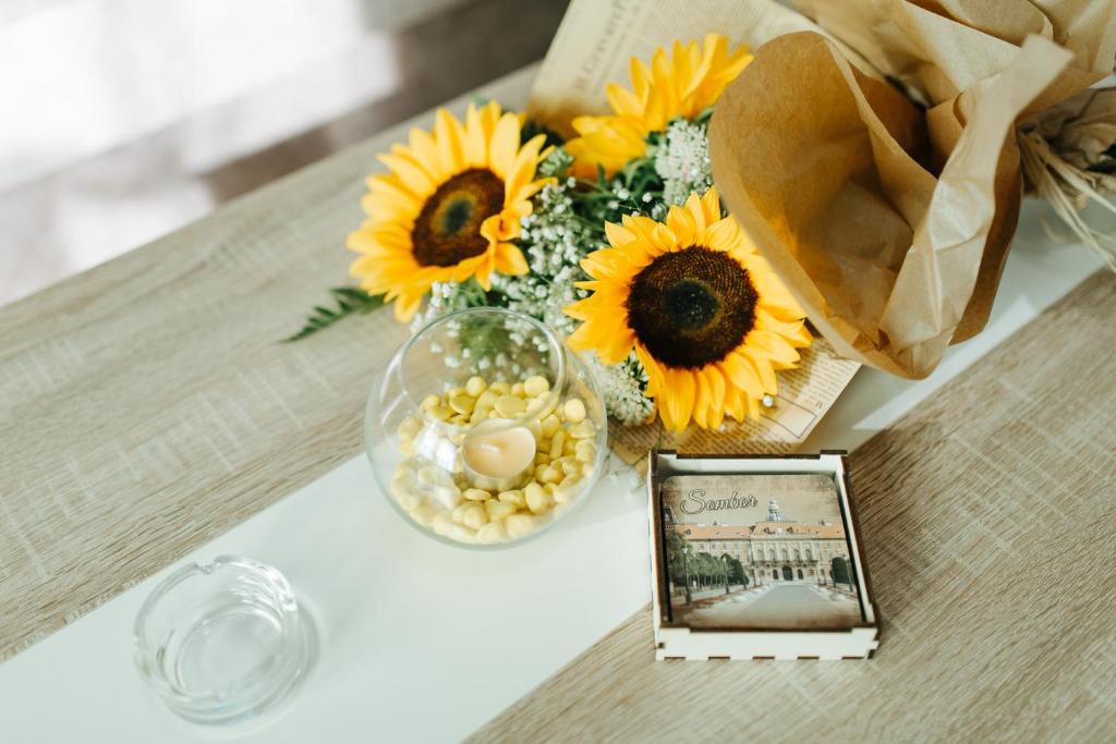 einen Tisch mit einer Vase Sonnenblumen und einem Bild in der Unterkunft Sunflower in Sombor