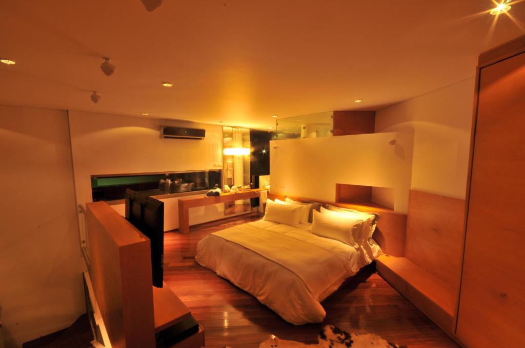 a bedroom with a large bed and a bathroom at AcquaSanta Lofts Hotel in Cali