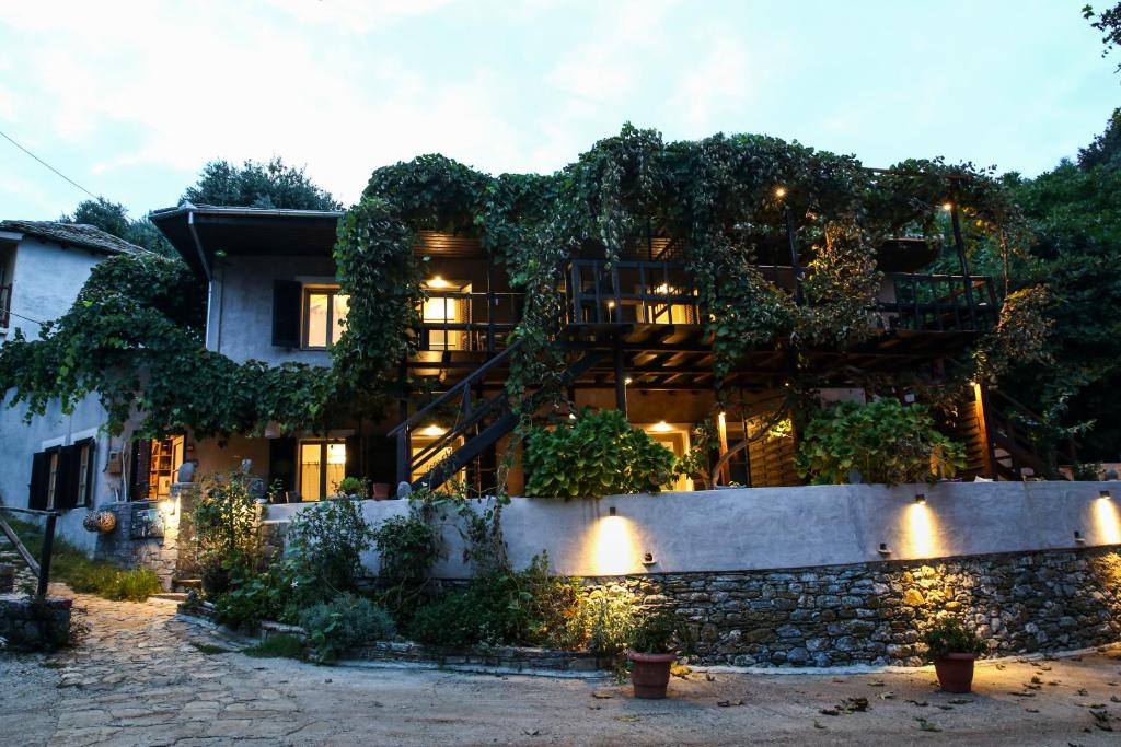 una casa cubierta de hiedra al atardecer en Ghermaniko Guesthouse, en Damouchari