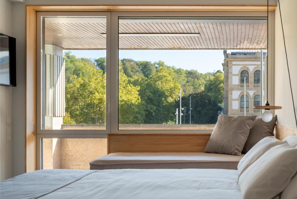 a bedroom with a large window and a bed at Cristina Enea Rooms in San Sebastián