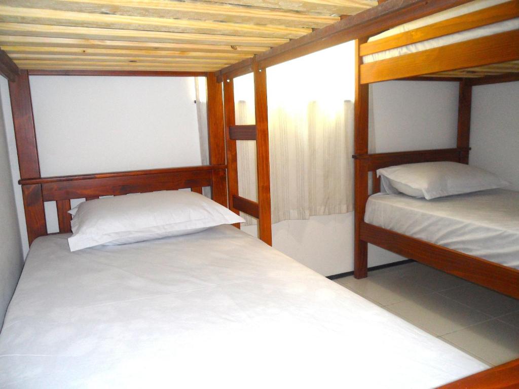 a bedroom with two bunk beds and a window at Hostel Borogodó in Fortaleza