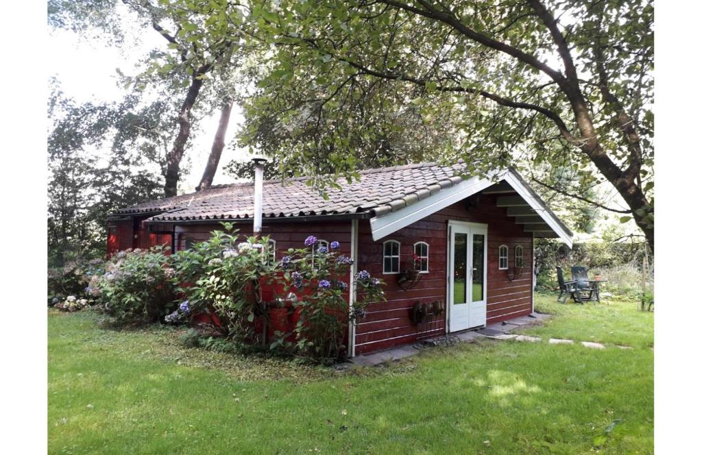 ein kleines Haus im Gras mit Blumen in der Unterkunft Het Swadde huisje in Twijzelerheide