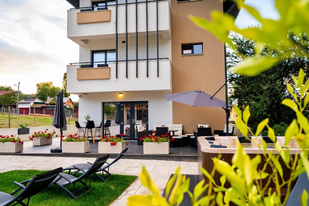 um edifício com um pátio com cadeiras e um guarda-sol em Velvet Home em Vatra Dornei