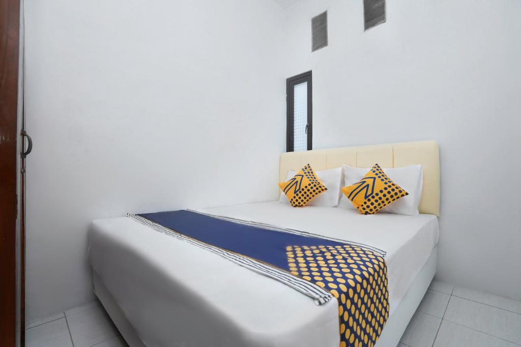 Una cama blanca con dos almohadas encima. en SPOT ON 2479 Berkah Residence Syariah, en Gresik