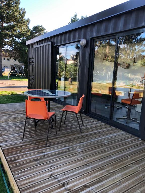 une petite maison avec une table et des chaises sur une terrasse dans l'établissement la kischte vintage, à Colmar