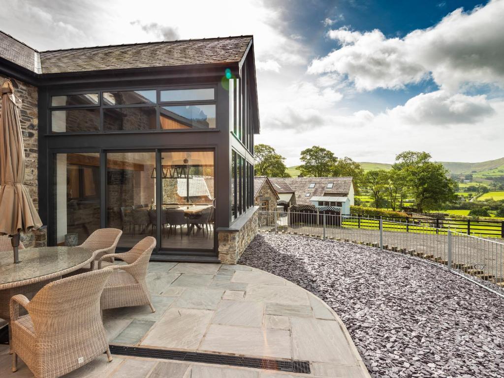 Ein Haus mit einer Terrasse mit einem Tisch und Stühlen in der Unterkunft Granar in Derwen