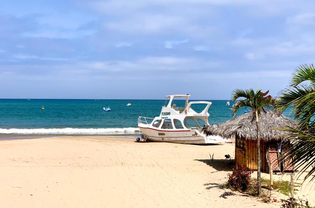 a boat sitting on the beach near the ocean at CASA DEL MAR in Ayangue