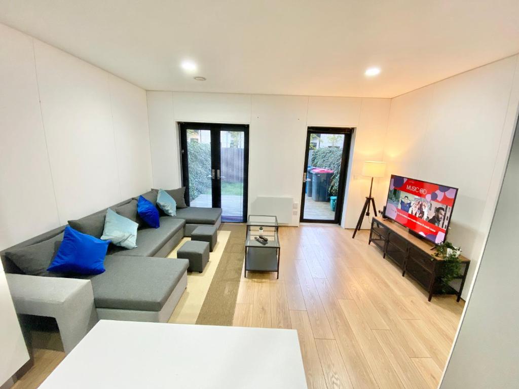 sala de estar con sofá y TV en Large Townhouse 5 Beds with Two Parking Spaces - Manchester City Centre, en Mánchester