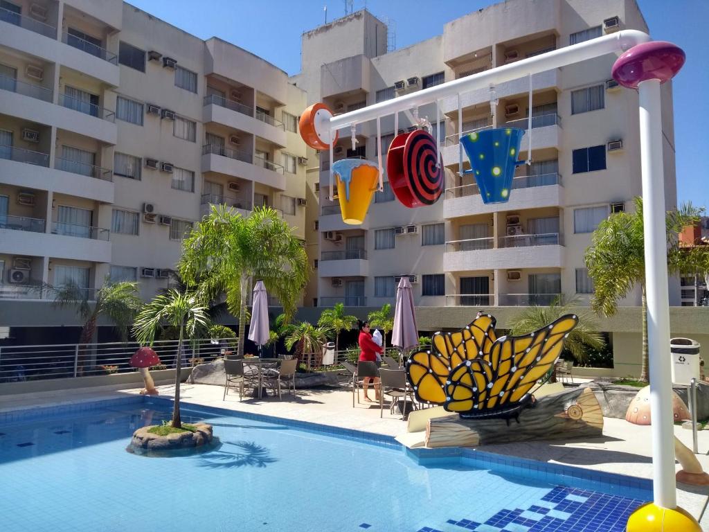 uma piscina com um hotel ao fundo em Serra Park Flat Service - Rio Quente Esplanada apartamento inteiro roupas de cama a parte em Rio Quente