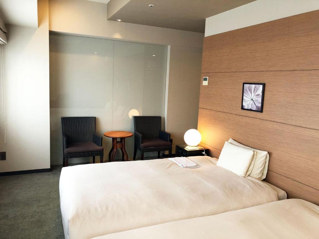a hotel room with a bed and two chairs at Citadines Central Shinjuku Tokyo in Tokyo