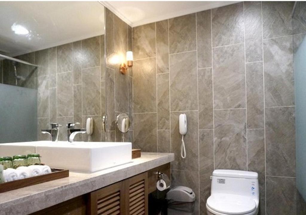 a bathroom with a sink and a toilet at Yang Ming Shan Tien Lai Resort &amp; Spa in Jinshan