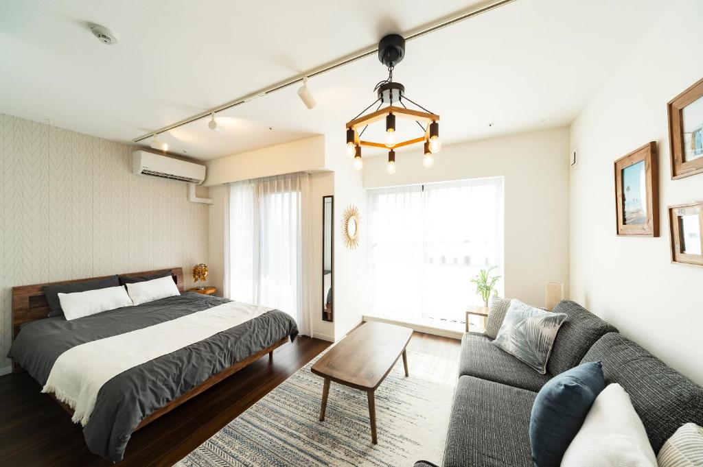 een slaapkamer met een bed en een bank bij GIVE Higashinakano in Tokyo
