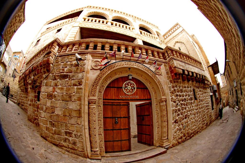 a large brick building with a large wooden door at Kadim Hotel in Mardin