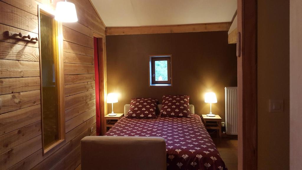 a bedroom with a bed and two lamps on two tables at Le Chalet du Parc in Annonay