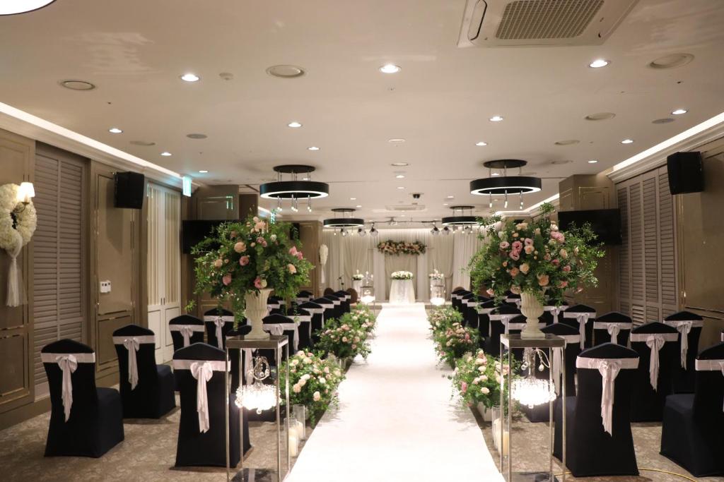 a banquet hall with chairs and a aisle with flowers at Arirang Hill Hotel Dongdaemun in Seoul