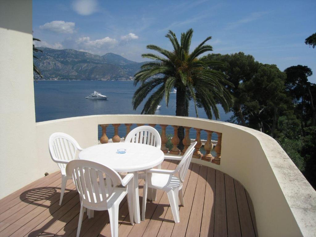 a table and chairs on a balcony with a view of the water at Hôtel de Charme Brise Marine in Saint-Jean-Cap-Ferrat