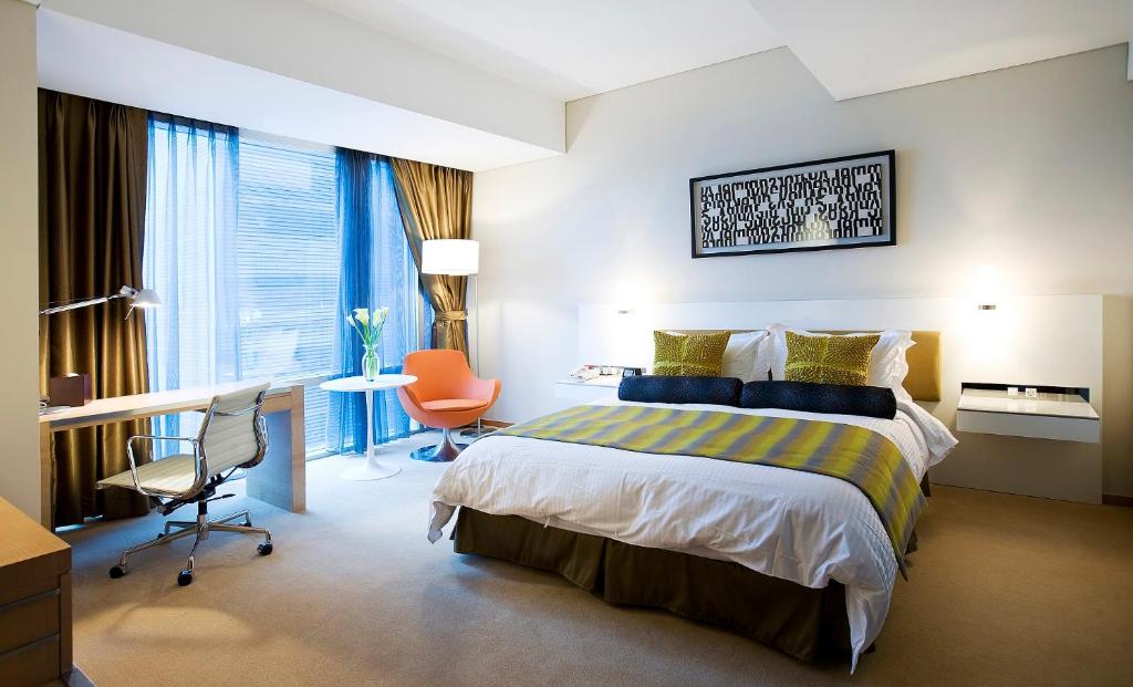 Pokój hotelowy z łóżkiem i biurkiem w obiekcie Ramada Plaza by Wyndham Suwon w mieście Suwon