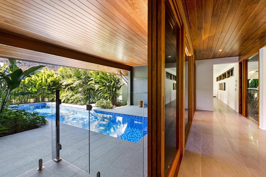an indoor pool is seen from the hallway of a house at Aqua - at Funnel bay in Airlie Beach