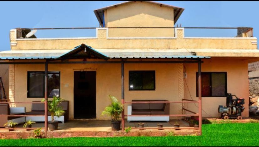 ein Haus mit einer Bank davor in der Unterkunft Savitri bungalow 3BHK in Panchgani