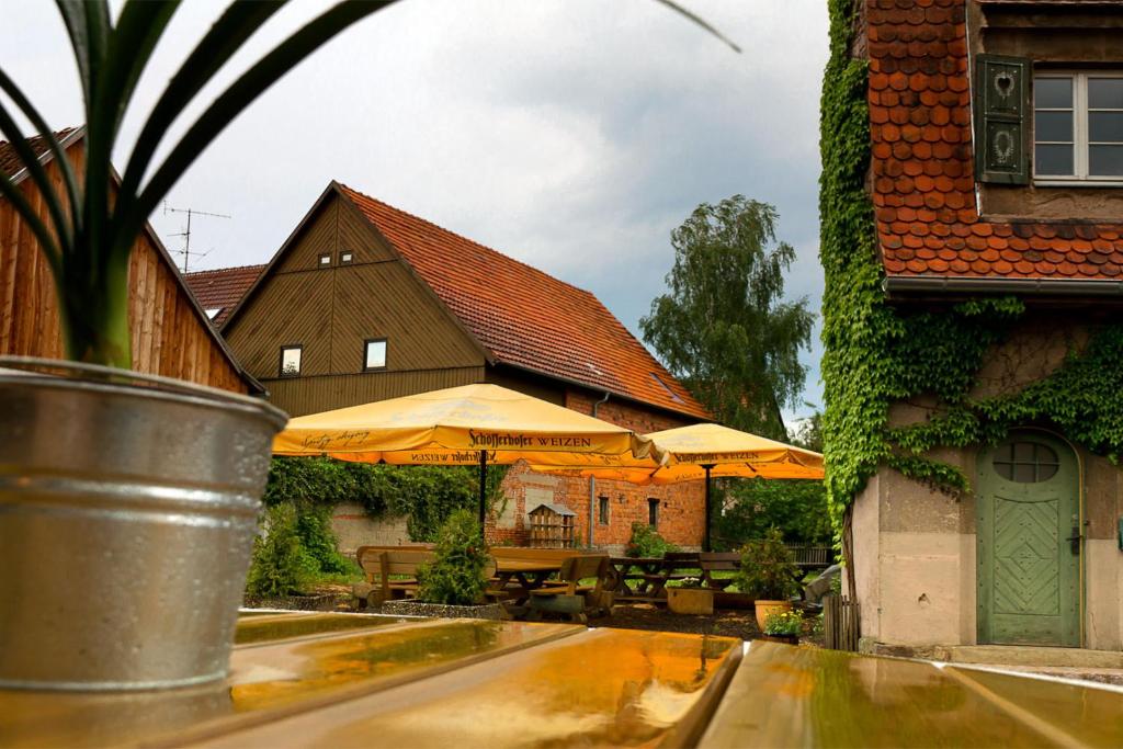 eine Terrasse mit Tischen und Sonnenschirmen vor einem Gebäude in der Unterkunft Gasthof Krone in Schönau an der Brend